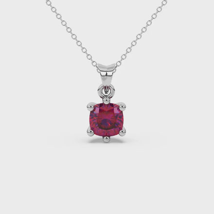 Red cushion cut gemstone solitaire pendant in gold featuring a refined six-prong basket setting