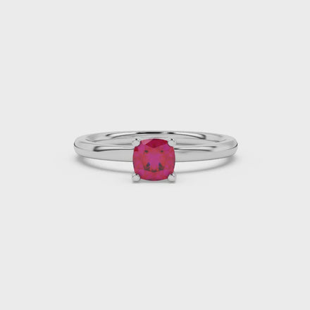 Red cushion cut gemstone solitaire ring in gold featuring a refined four-prong cathedral basket setting